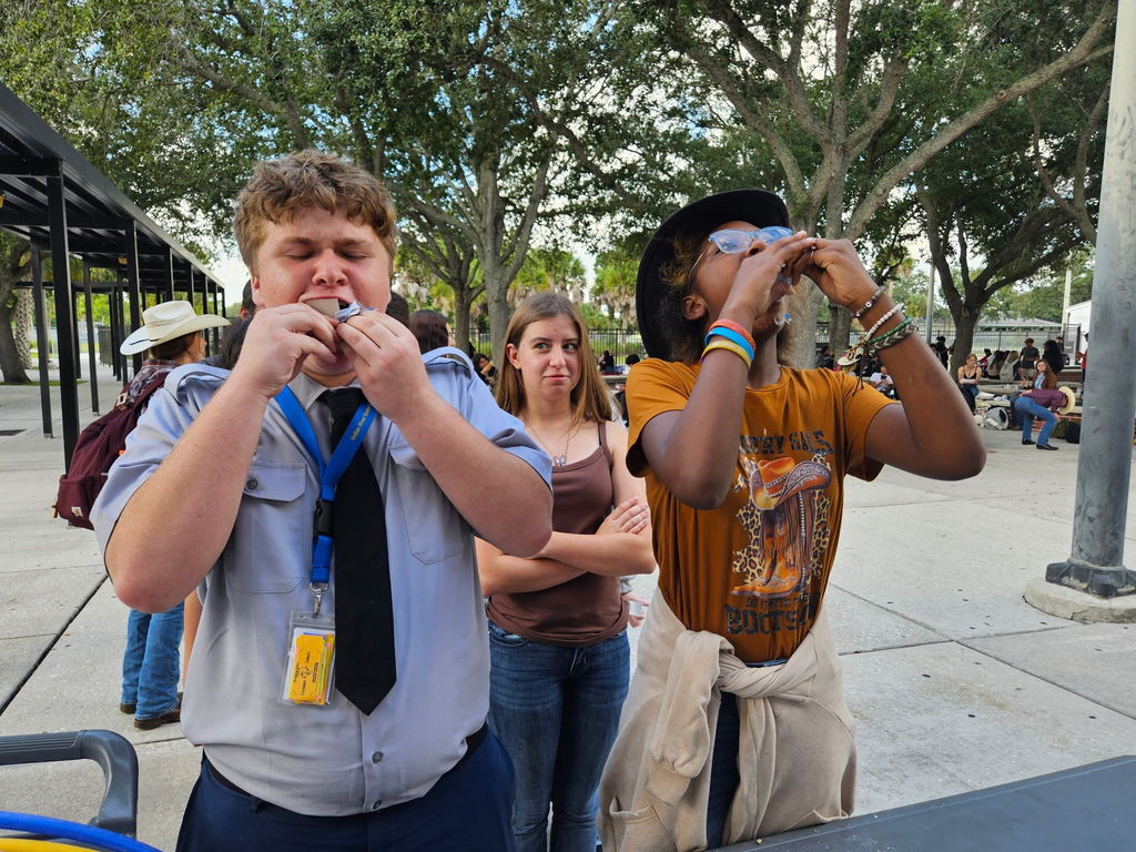 two students eating doughnuts for homecoming competition and girl staring