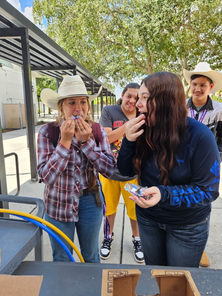 two girls eating doughnuts and two boys staring 