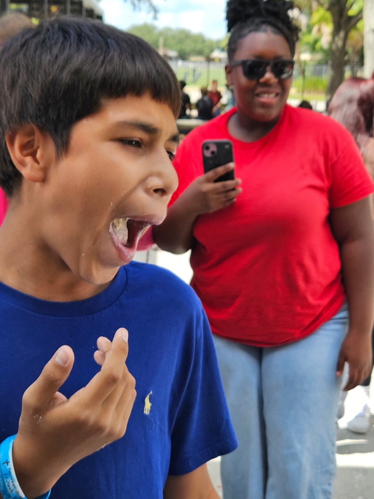 student with mouth open and doughnuts inside