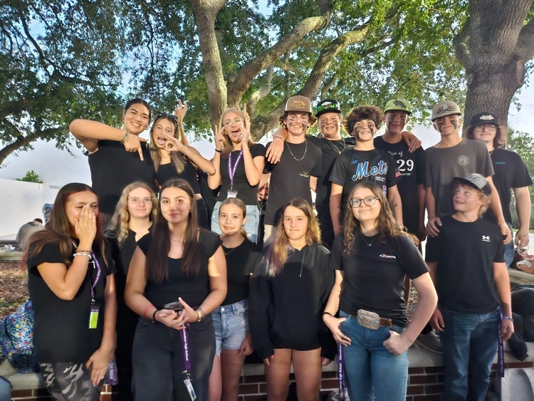 big group of students wearing black in school courtyard 