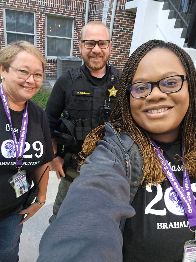 principal and assistant principal standing next to SRO in school courtyard