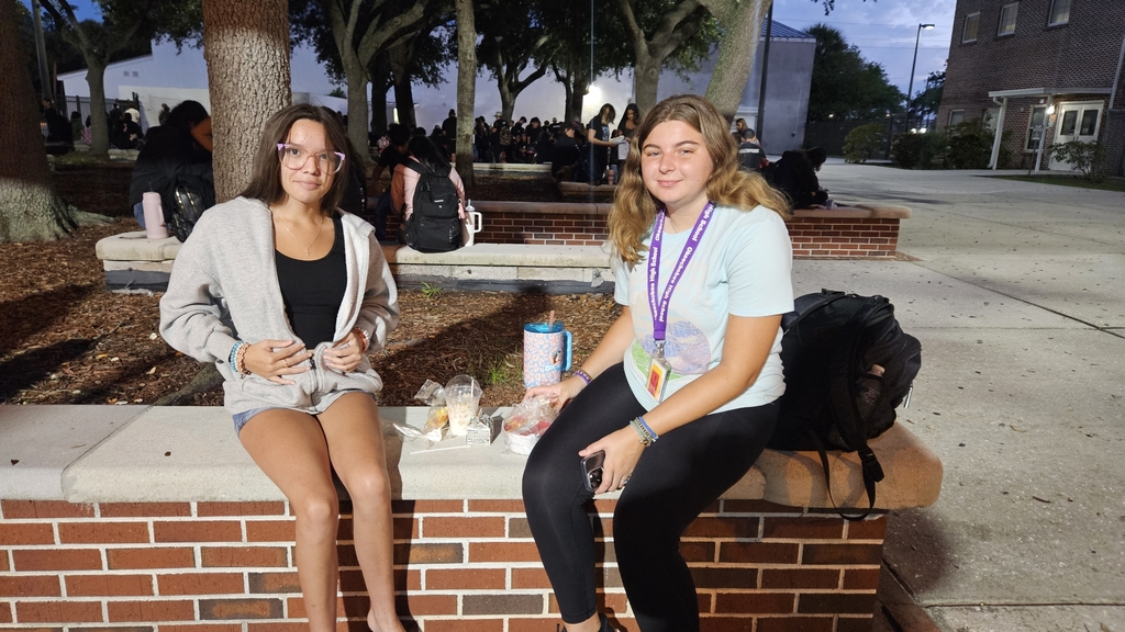 two girls sitting in courtyard early in the morning