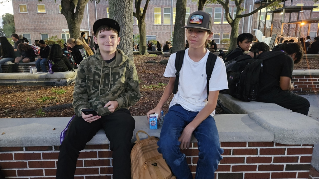 two students sitting in courtyard early in the morning