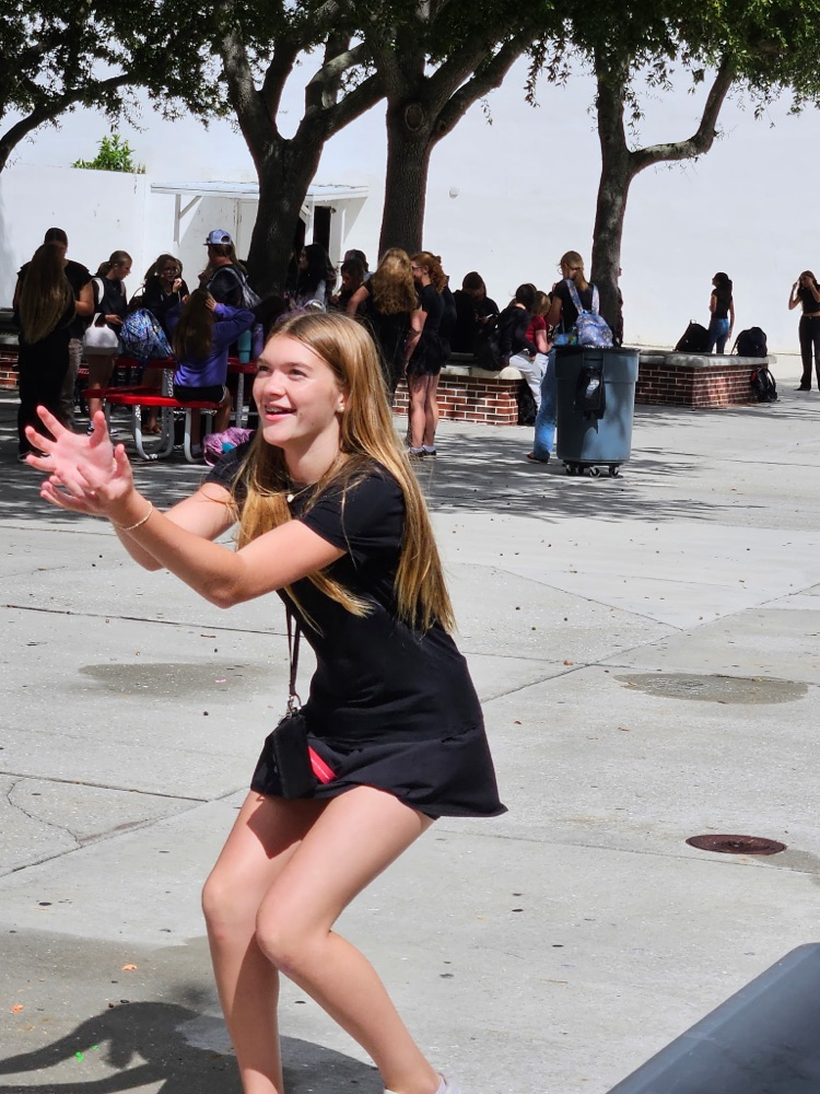 student playing water balloon game in courtyard