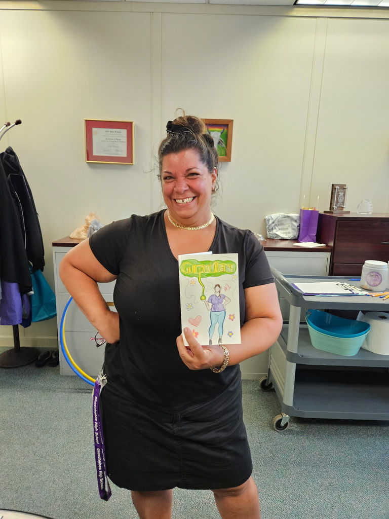 custodian smiling showing cards from students
