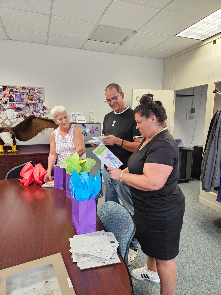 three custodians looking at cards in main office of school