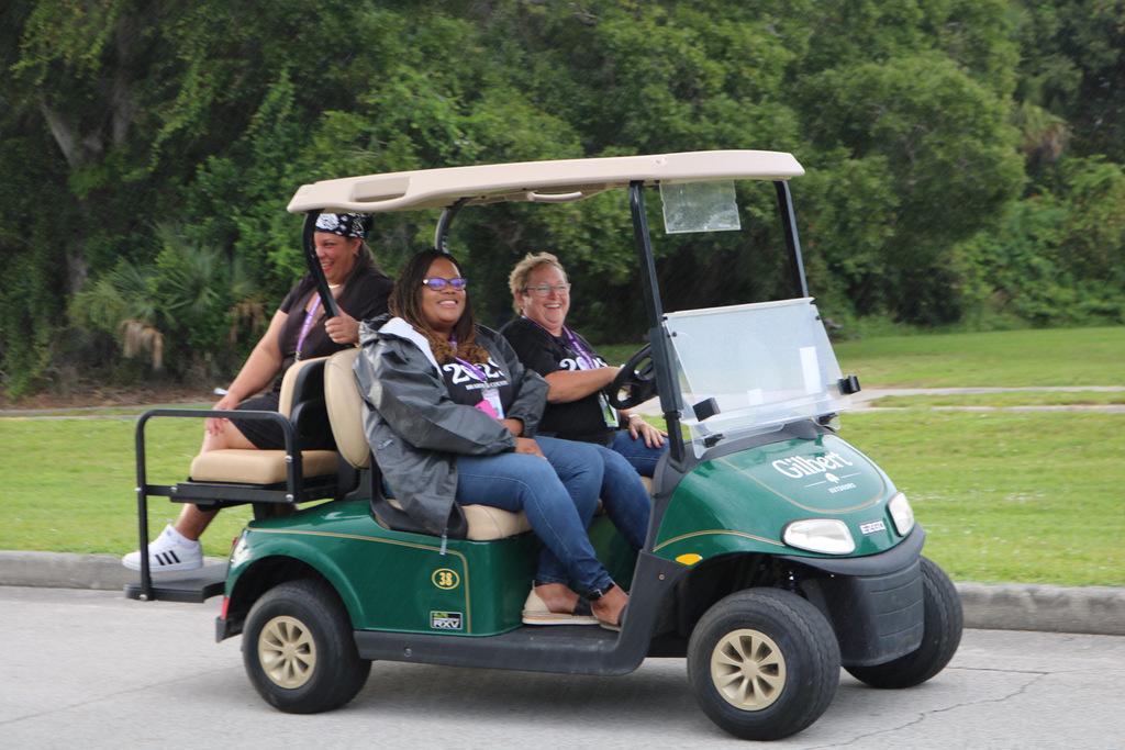 principal, assistant principal, and custodian sitting on golf cart