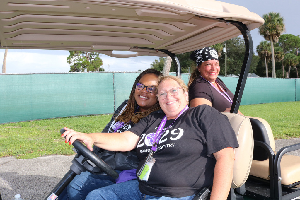 principal, assistant principal, and custodian sitting on golf cart