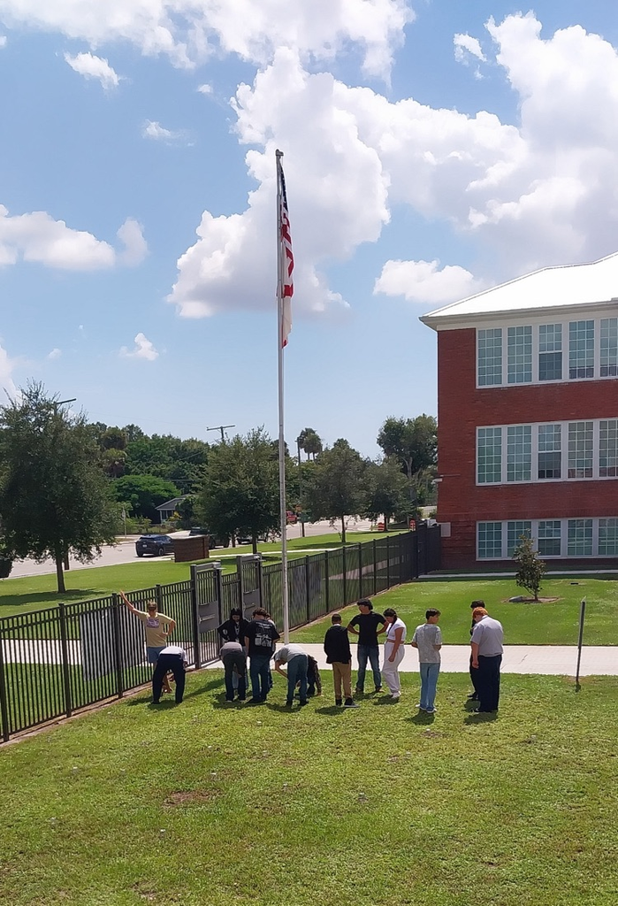 students doing science project by flagpole 