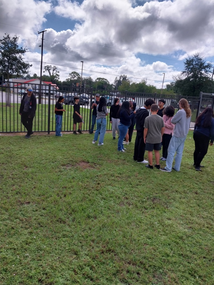 students doing science project by flagpole 
