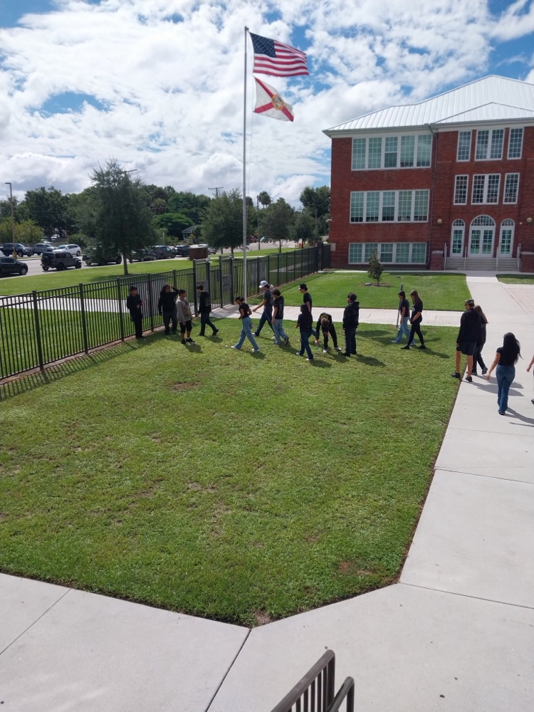 students doing science project by flagpole 