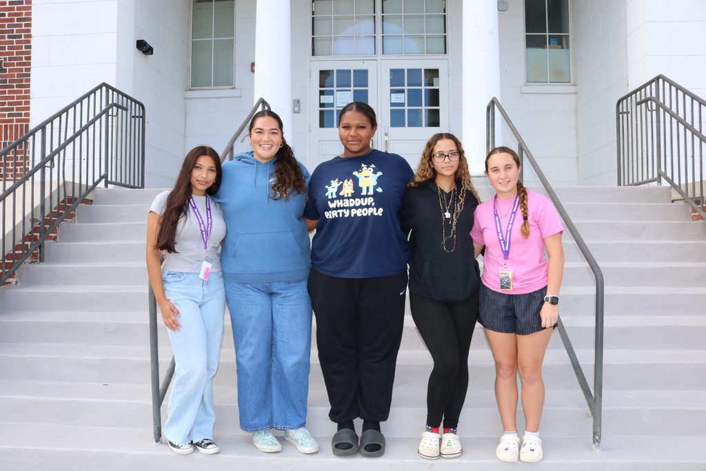 governing board consisting of 5 female students on steps of school
