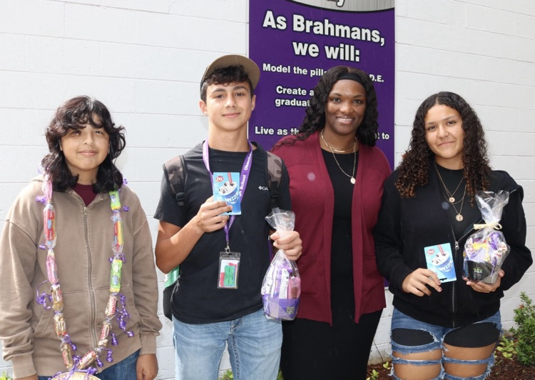 guidance counselor with three students holding attendance gifts