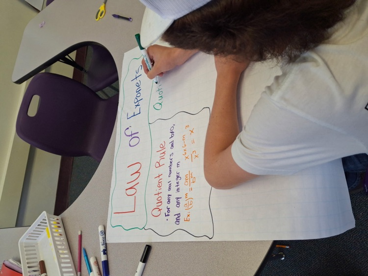 student working on poster in algebra