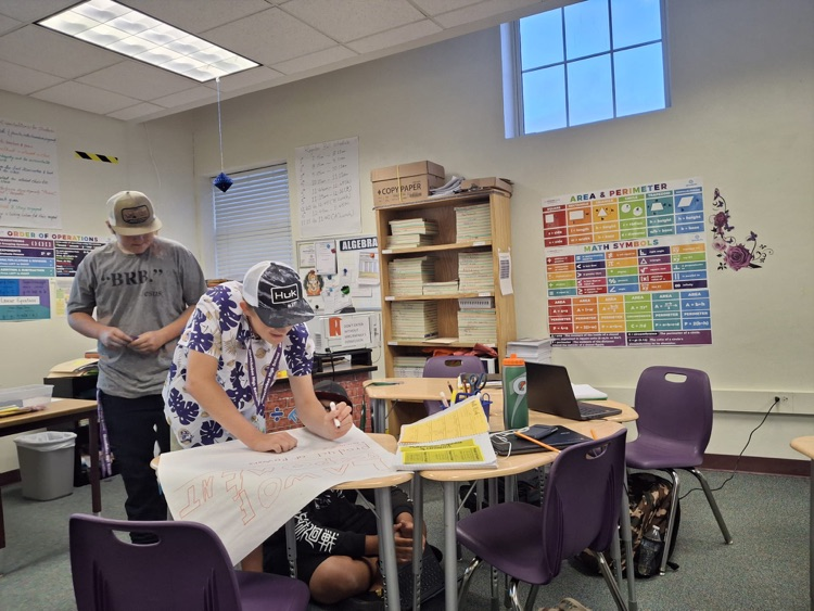 students working on algebra posters in class
