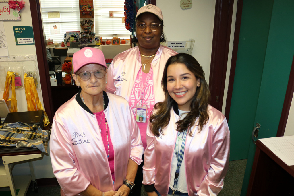 three school members wearing pink ladies jacket in office