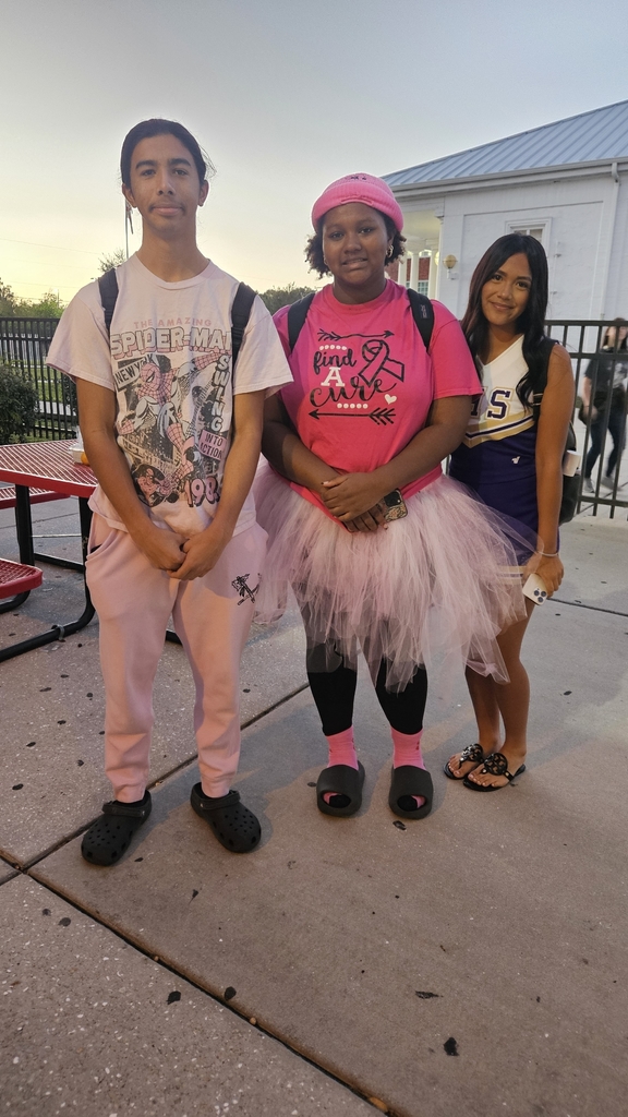 three students standing outside in school courtyard
