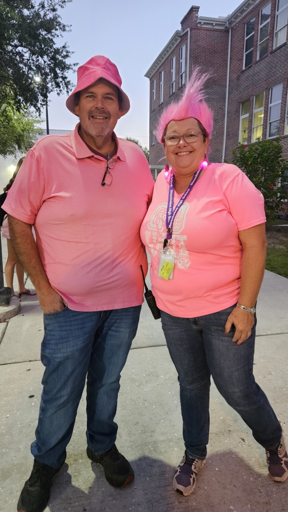 principal and Ag teacher wearing pink outside in school courtyard
