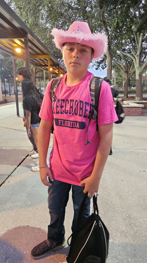student outside in school courtyard wearing pink for breast cancer awareness