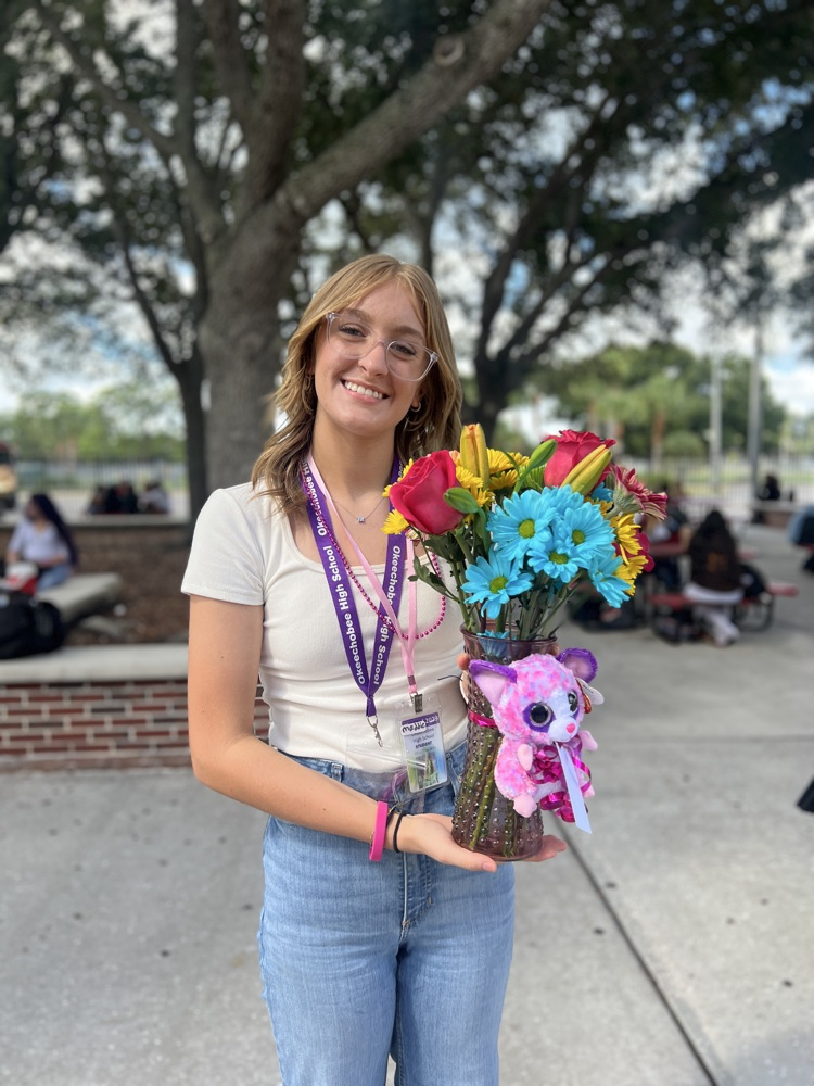 student showing off flowers in courtyard