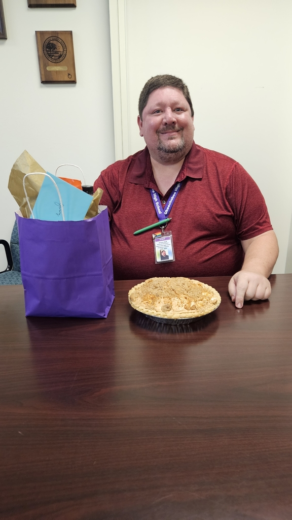 instuctional coach sitting with pie and gift