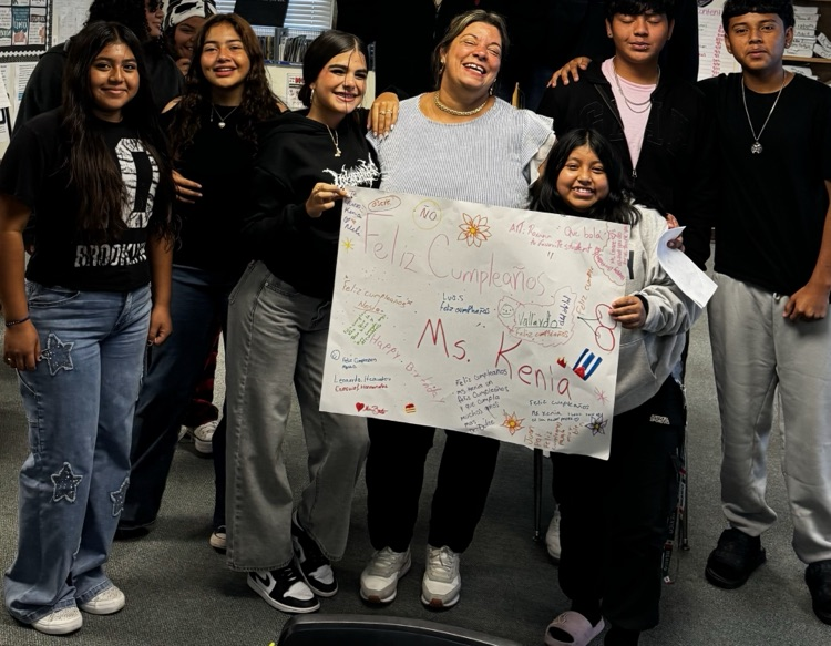 custodian holding happy birthday sign with students