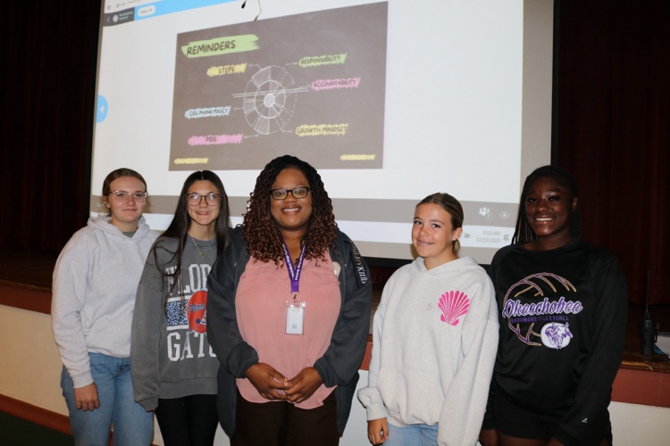 AP with four girls infront of auditorium stage