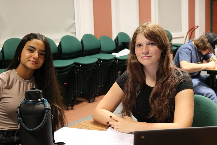 two girls smiling in townhall meeting