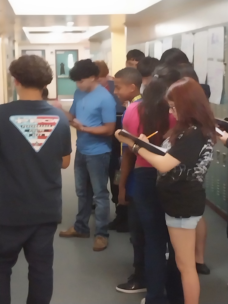 students writing and looking at posters on lockers