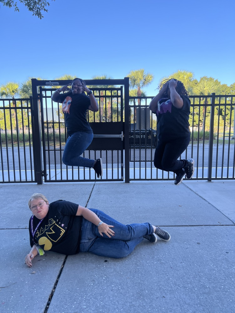 principal on the floor and two teachers jumping