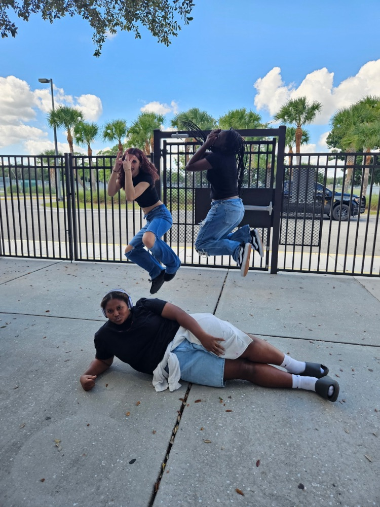 one student on floor and two students jumping