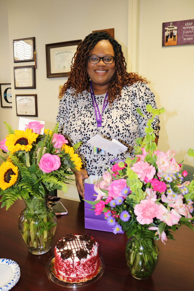 assistant principal with two flower vases and birthday cake in office