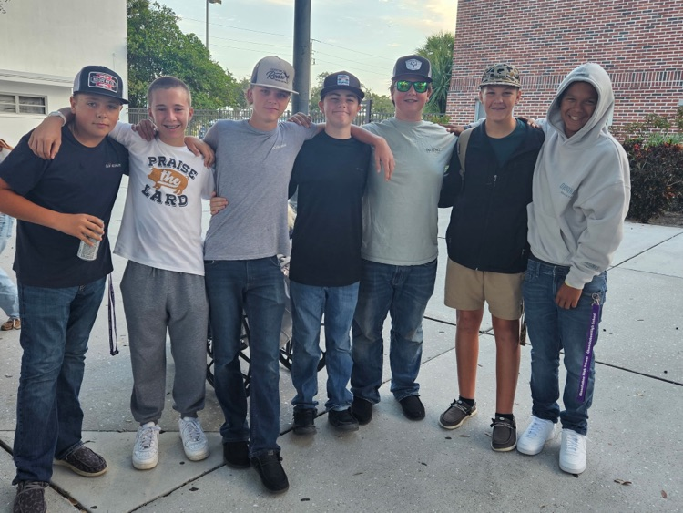 seven boys hugging outside school courtyard
