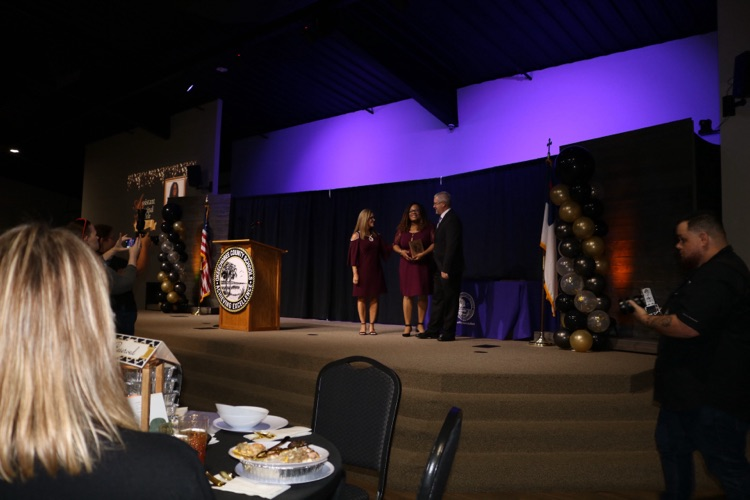 assistant principal on stage at banquet with superintendent