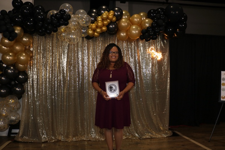 assistant principal holding plaque