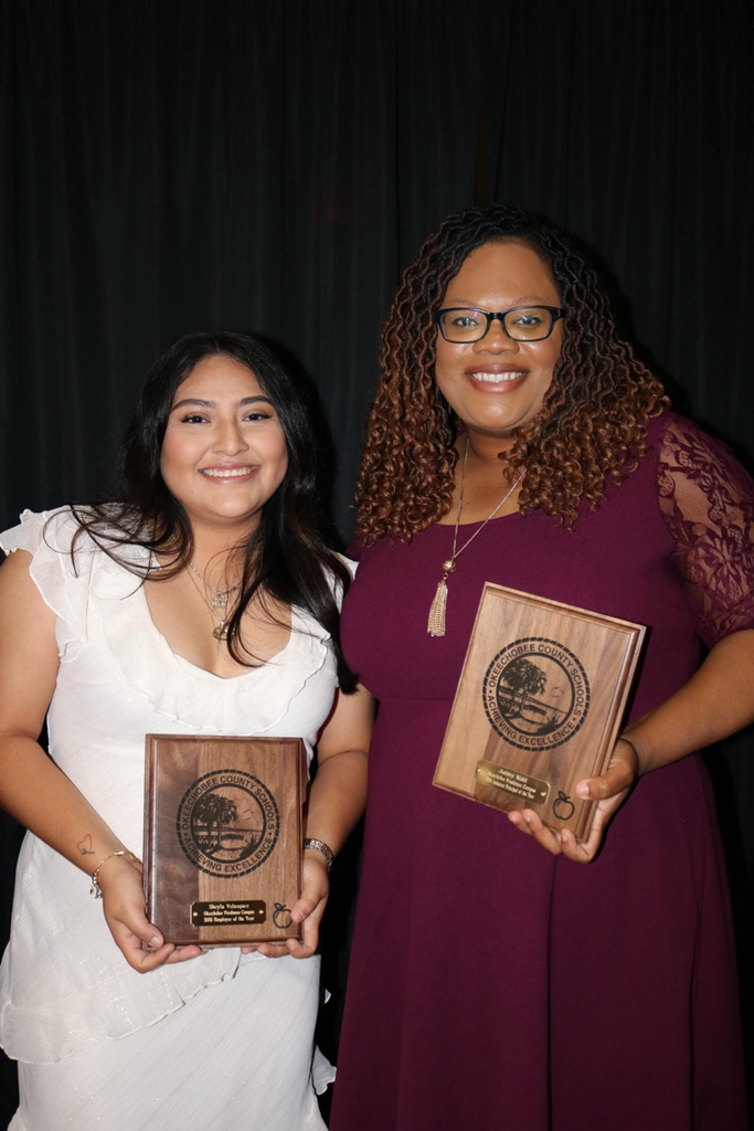 assistant principal with secretary holding plaques