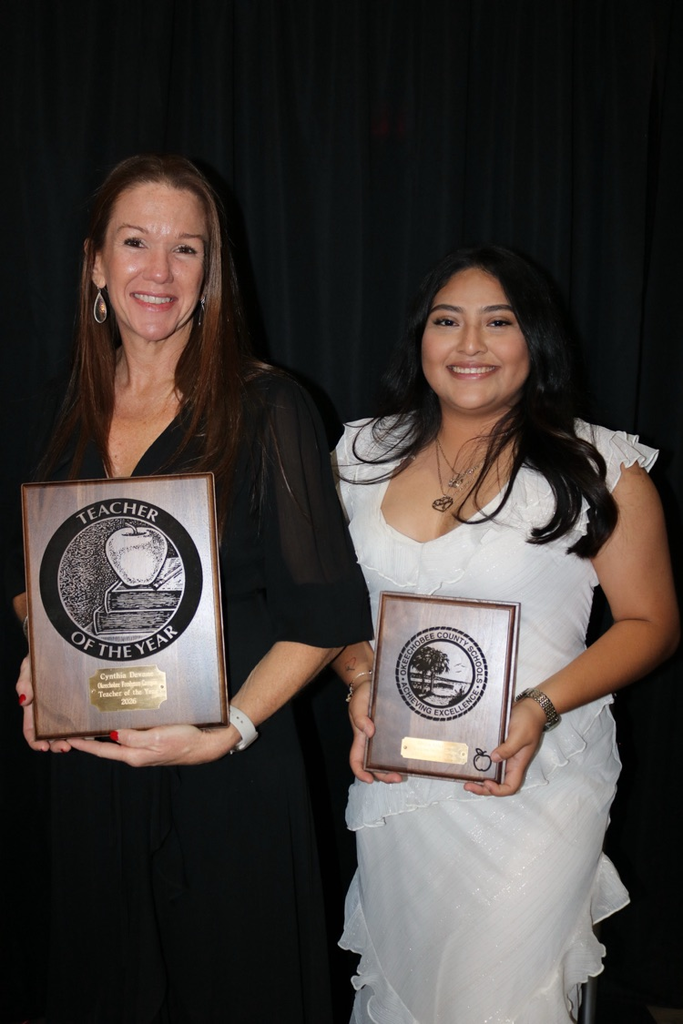 teacher of the year and employee of the year holding plaques
