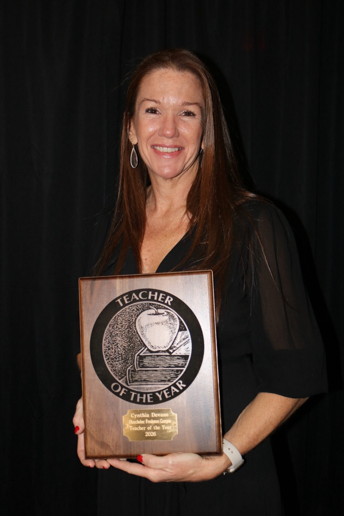 teacher of the year holding plaque
