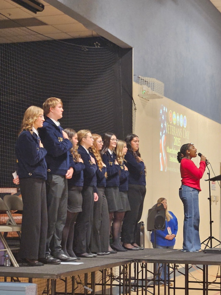 student singing and ffa behind her on stage