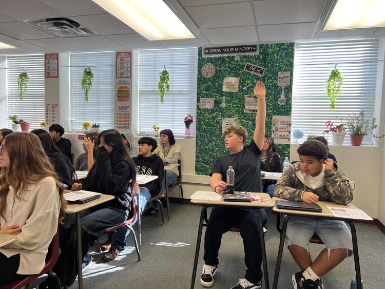 student raising their hand to talk to counselor