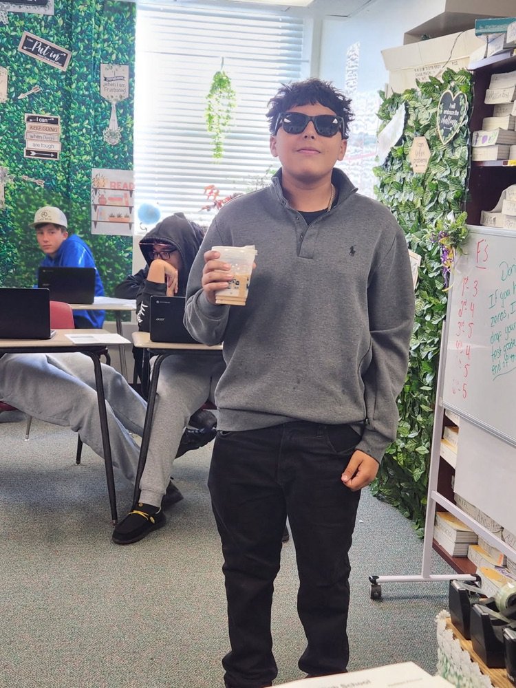 student with sunglasses in class with coffee cup