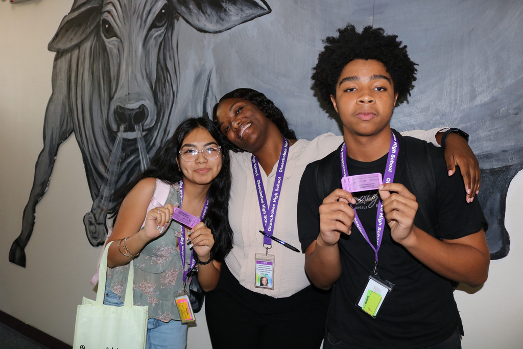 guidance counselor hugging students showing extra credit passes