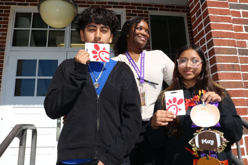 two students with guidance counselor outside 