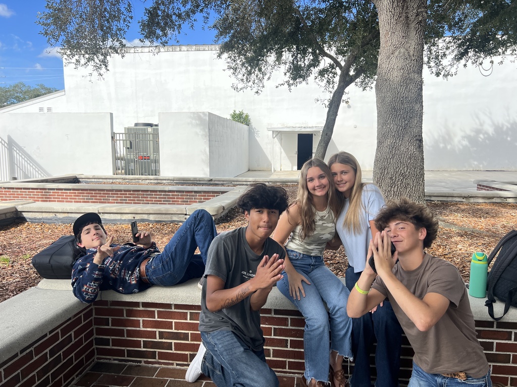 five students hanging out in school courtyard