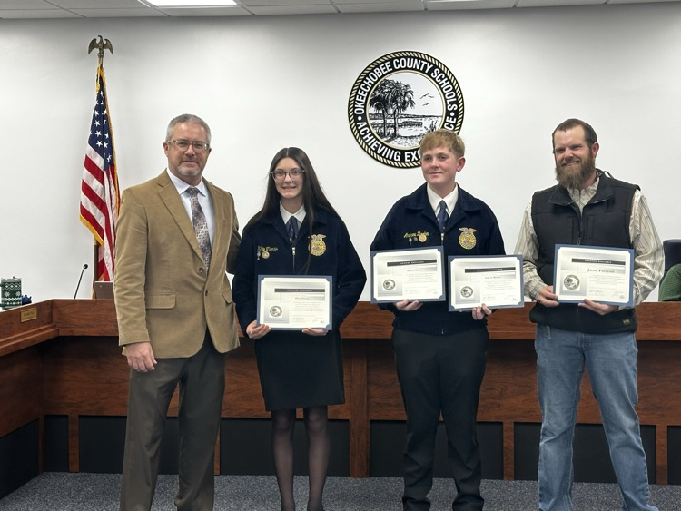 superintendent with three ffa students being recognized