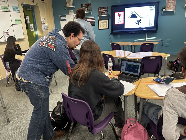 students working with teachers in algebra classroom