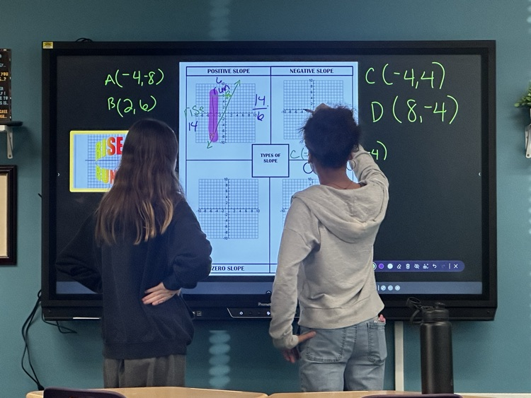two students learning algebra on the board in classroom