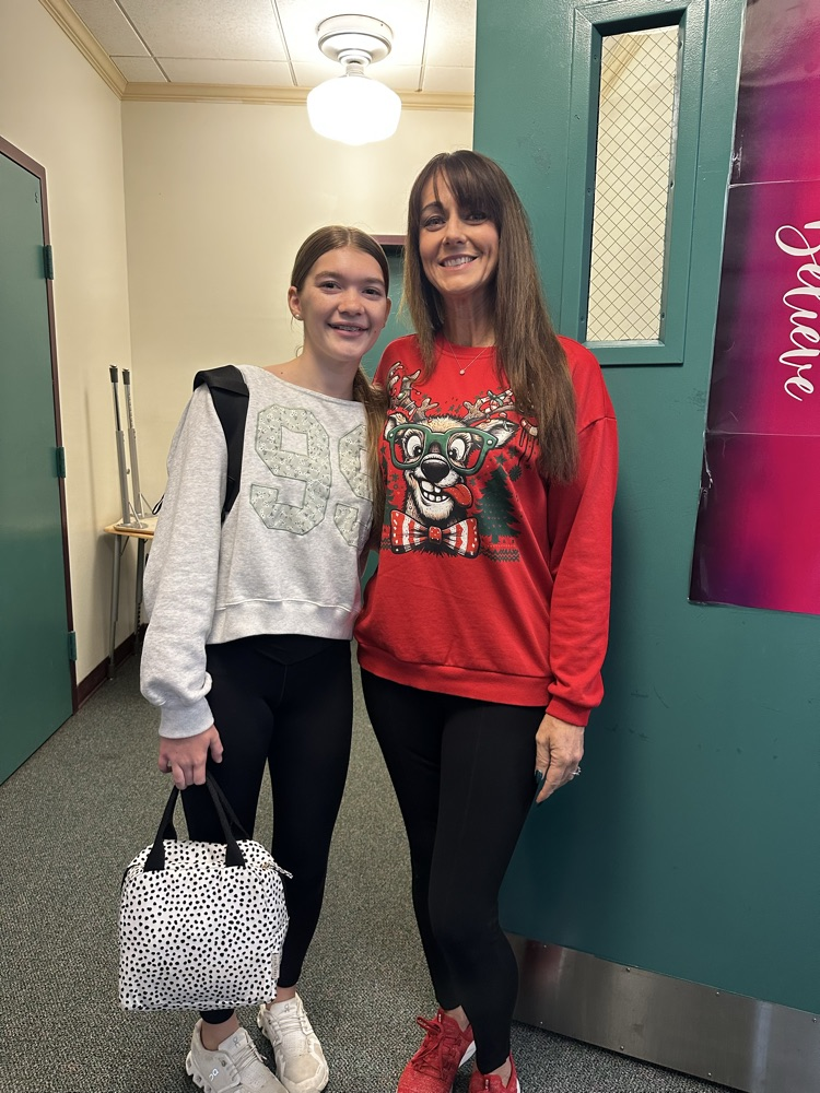 teacher and student wearing ugly Christmas sweater 