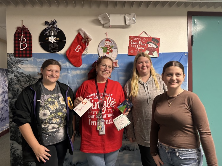teacher holding giftcard won by students 