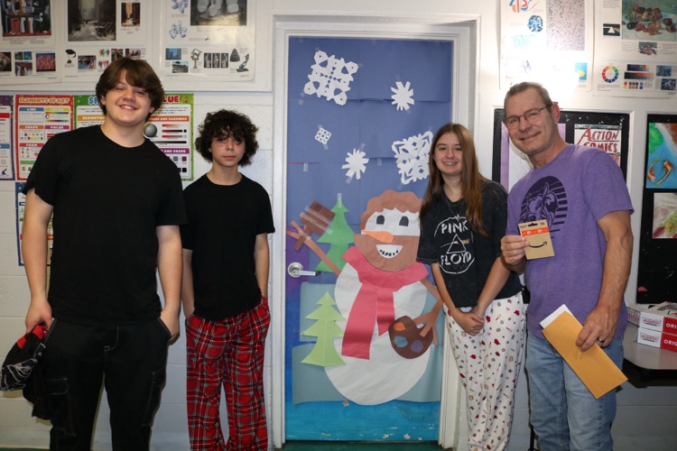 students standing by decorated door in art class